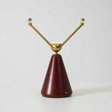 The two brass arms of the lamp seen from the front, plain ground