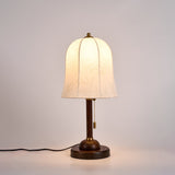 Gold and white table lamp lit, seen from three quarters