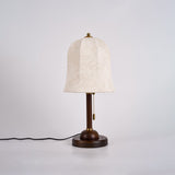 Gold and white table lamp unlit, the floral print on the shade visible