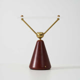 The wood cone base of the lamp seen against a plain ground
