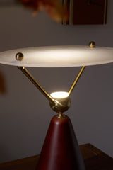 The frosted disc of the lamp seen lit from above