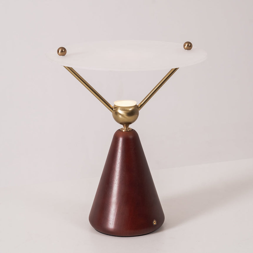 Gold and white table lamp seen straight on against a plain ground