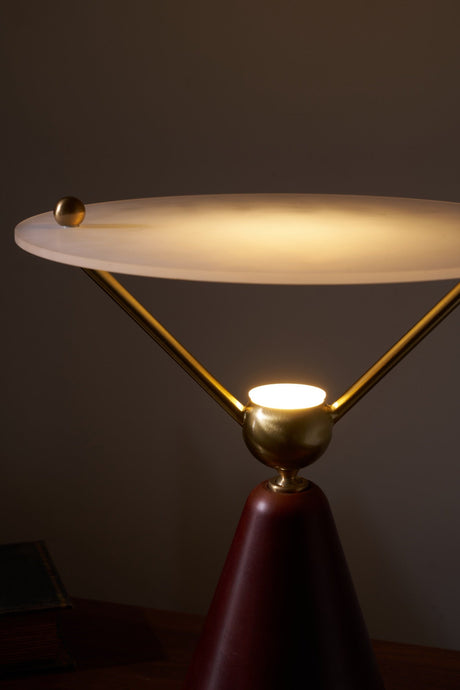 Close view of the brass sphere and the arms under the lit disc