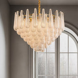 The fitting lit beside a tall arched window with fine glazing bars