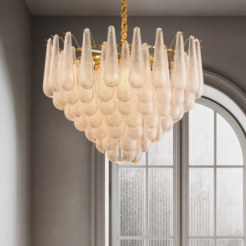 The fitting lit beside a tall arched window with fine glazing bars