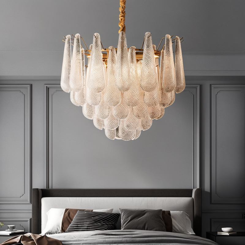 The fitting lit above a bed with pillows against a paneled gray wall