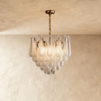 A gold chandelier with tiers of patterned glass petals falling in a shallow cone