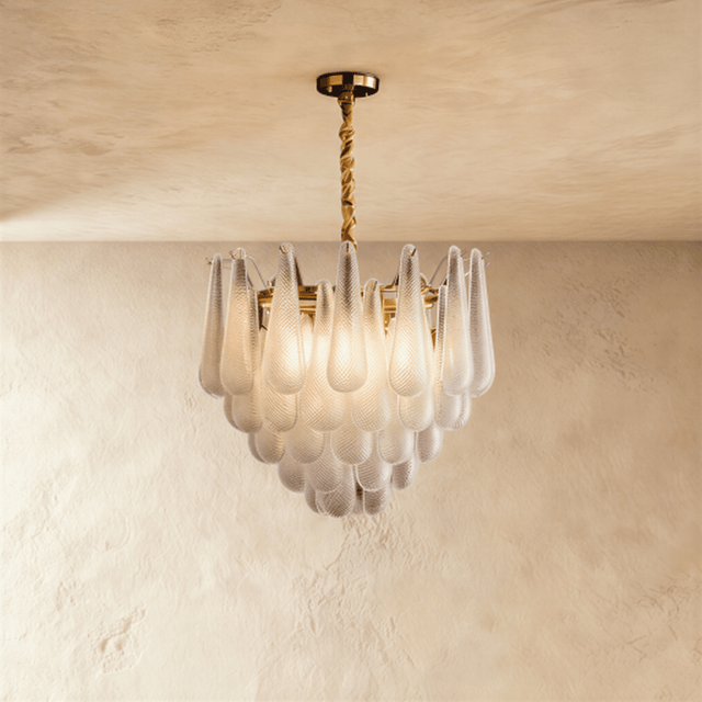 A gold chandelier with tiers of patterned glass petals falling in a shallow cone