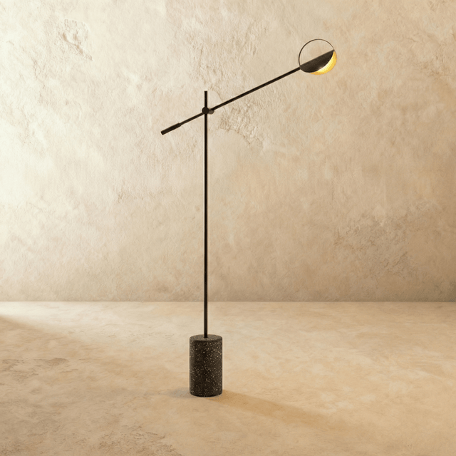 A long black arm balanced across a slim upright above a speckled terrazzo cylinder
