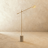 The same balanced arm in gold with a shallow disc shade at its far end