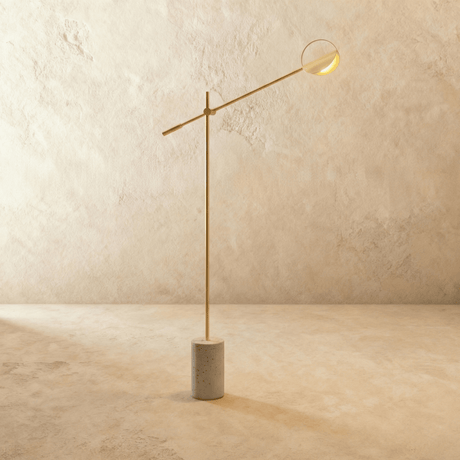The same balanced arm in gold with a shallow disc shade at its far end