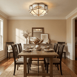Scalloped brass ceiling light above a dining table with a mirror behind