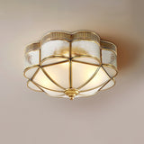 Scalloped brass ceiling light seen from the side on a pale backdrop