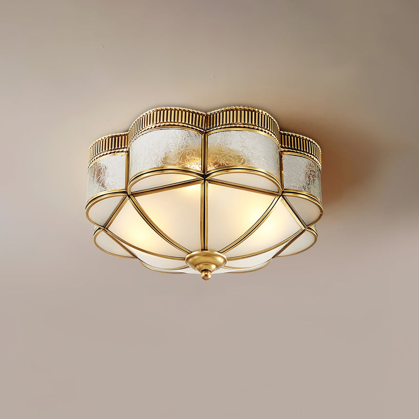 Scalloped brass ceiling light on a plain ceiling seen straight on