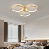 Three ring gold ceiling light in a bedroom with long curtains