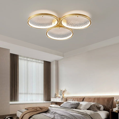 Three ring gold ceiling light in a bedroom with long curtains