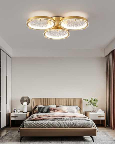 Three ring gold ceiling light in a bedroom with a wardrobe wall