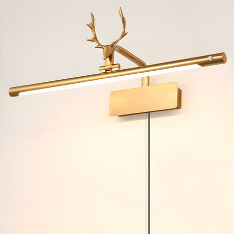 The gold version lit on a pale wall, the cord hanging free below the plate