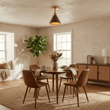 Cone ceiling light lit above a round dining table with a plant and wood chairs