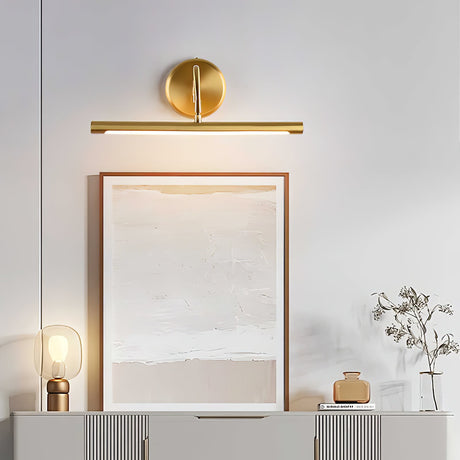 Gold bar lit over a framed canvas standing on a ribbed sideboard with a vase