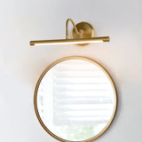 Gold bar mounted above a round gold framed mirror on a white wall