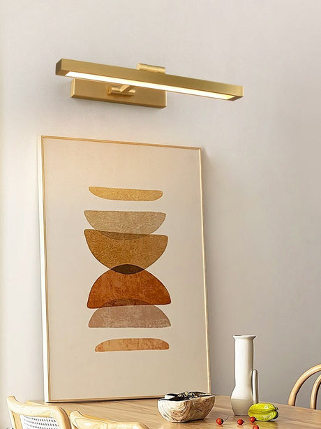 Gold bar lit over a framed print above a wood dining table and bowls