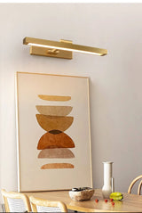 Gold bar over a framed print, dining chairs and a small vase below it