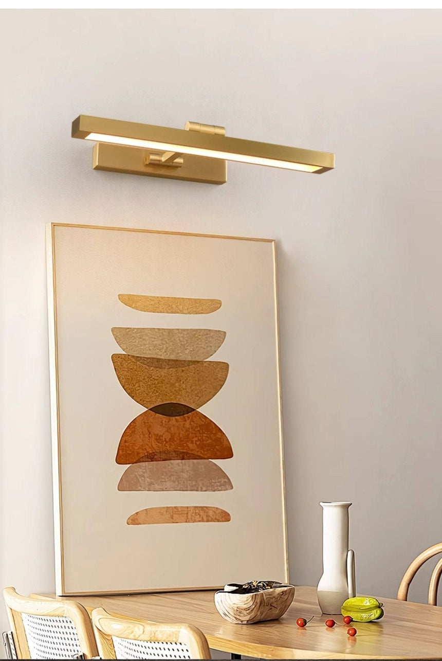 Gold bar over a framed print, dining chairs and a small vase below it