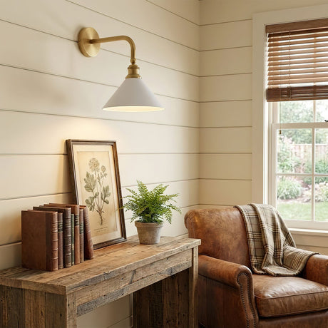 The sconce above a rustic console with books and a plant beside a leather chair