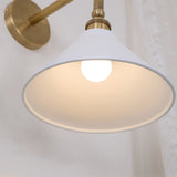 Inside the white cone shade, the bulb lit under the brass socket