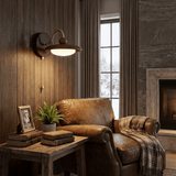 Sconce lit on a plank wall beside a leather chair and a stone fireplace