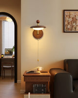 Sconce lit beside an arched doorway above a desk chair and a framed print