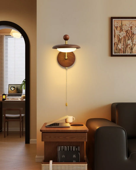 Sconce lit beside an arched doorway above a desk chair and a framed print