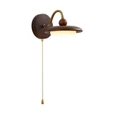 The curved gooseneck arm in profile carrying the saucer shade and pull chain