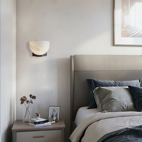 The lit bowl above a nightstand beside a bed with gray linens