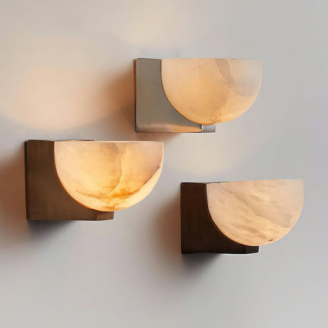 Three bowls in different finishes lit on a plain wall