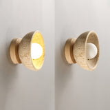 A lit fitting and an unlit one on a pale wall, the bowls facing outward