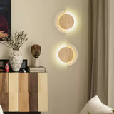 A pair of lit sconces on a living room wall above a wood sideboard