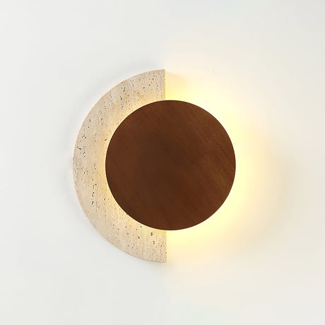 Travertine crescent lit behind a dark walnut disc against a white wall