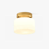 Hallway flush mount ceiling light with a white glass drum and a brass canopy