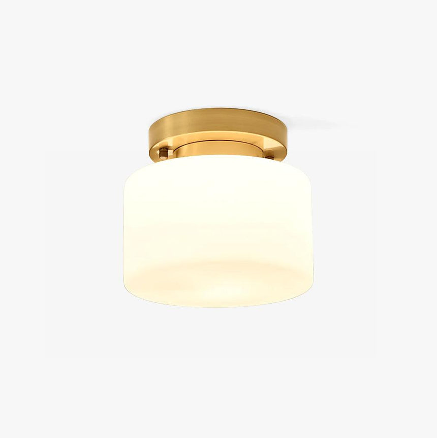 Hallway flush mount ceiling light with a white glass drum and a brass canopy