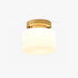Hallway flush mount ceiling light with a white glass drum and a brass canopy