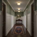 Brass and white glass ceiling lights in a green corridor with a patterned runner