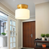 Brass and white glass ceiling light above a hallway with a dark wood door