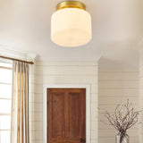 Brass and white glass ceiling light beside a wood door and a curtained window