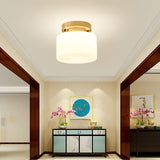 Brass and white glass ceiling light in a corridor with a painted cabinet