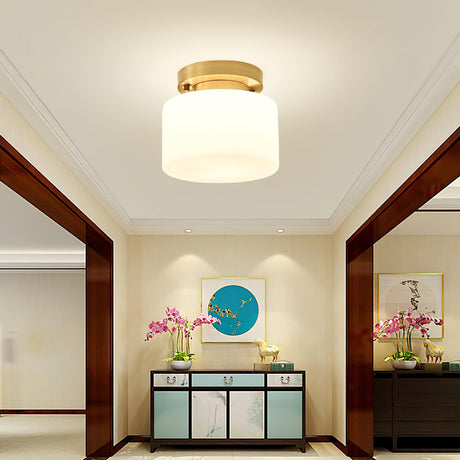 Brass and white glass ceiling light in a corridor with a painted cabinet