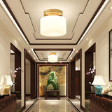 Brass and white glass ceiling lights along a corridor with a coffered ceiling