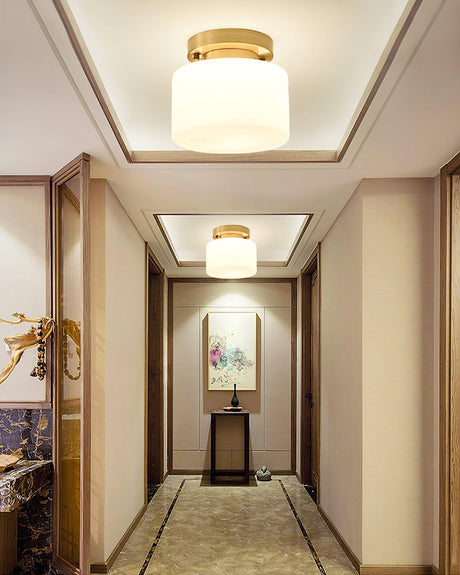 Brass and white glass ceiling lights in a corridor with a stepped ceiling