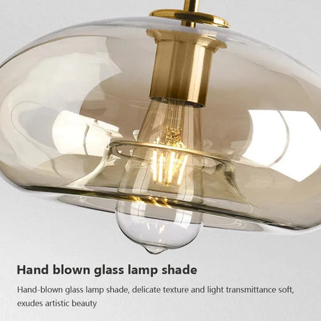 Close view of the amber glass and brass holder with a lit bulb inside